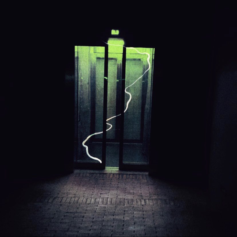 An elevator with a green glow and a white smoke-like trail within