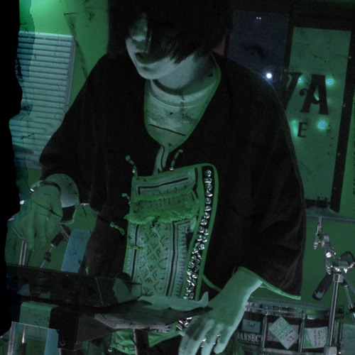 An image of a person reaching toward a small casio-like sampler keyboard. The image is tinted green