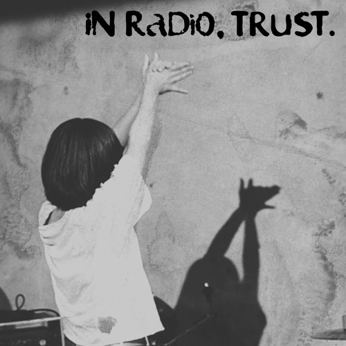 Someone holding their hands up. Its shadow casts a dog-head. A title reads 'IN RADIO, TRUST.'.